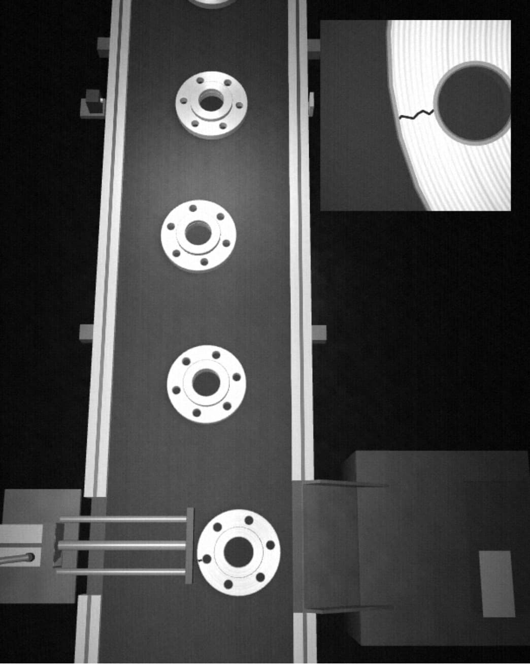 Imagen monocroma de una cinta con bridas de aluminio bajo la cámara de inspección, con el expulsor sacando una pieza con grieta hacia la caja de rechazo